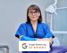 Portrait of female doctor dentist in office. Confident middle aged woman looking at camera with crossed arms near dental chair. Dentistry, medicine, specialist, career, dental health care concept